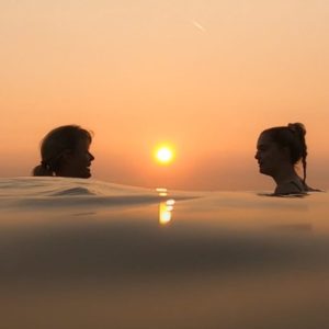 An image of two women swimming in the sea