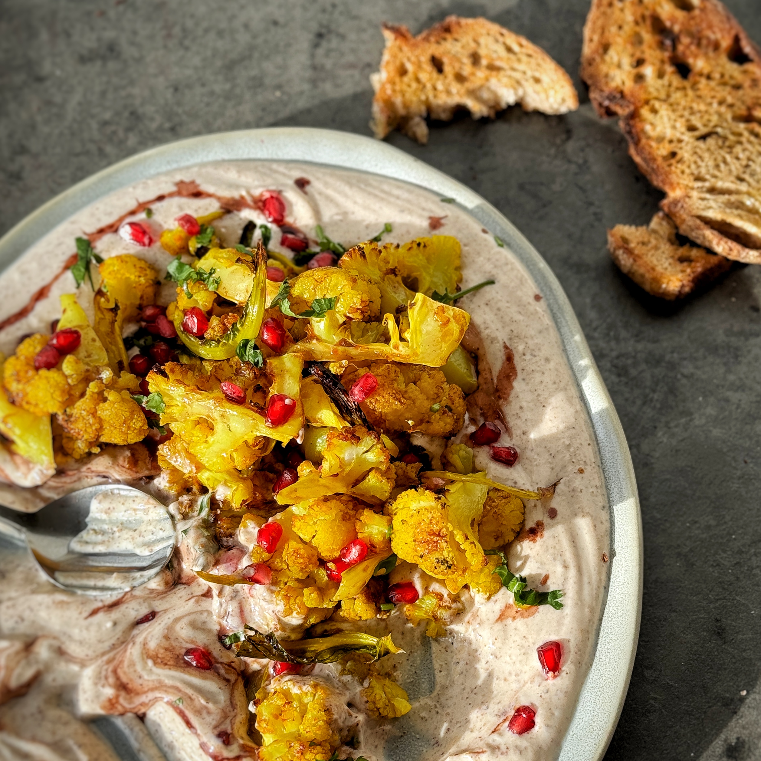 An image of Golden Cauliflower Florets with Almond Cream and Pomegranate