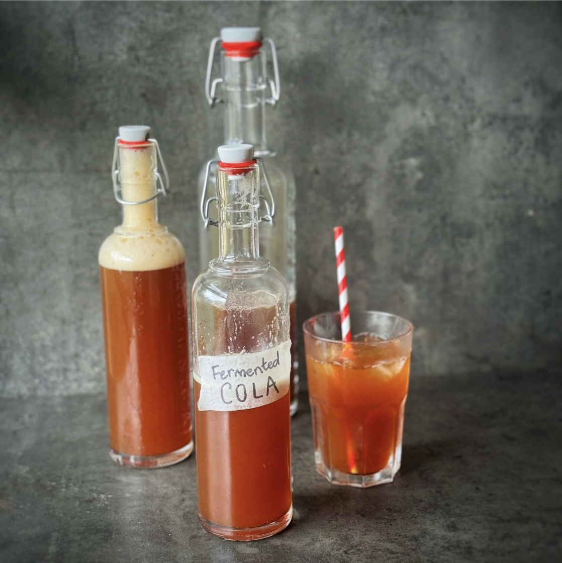 Photo of several glass bottles of naturally fermented cola